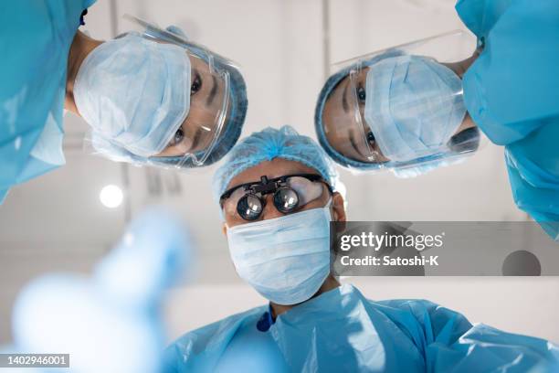 surgeons looking at the patient from directly above - surgical loupes stock pictures, royalty-free photos & images