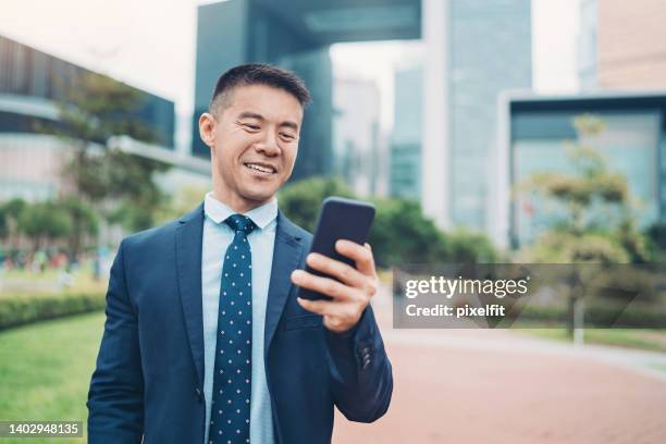 smiling entrepreneur with cell phone - mid volwassen mannen stockfoto's en -beelden