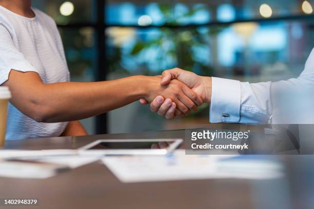 uomo e donna d'affari che si stringono la mano in ufficio. - handshake foto e immagini stock