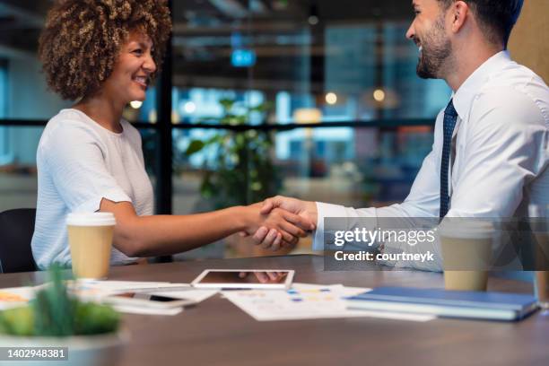 geschäftsmann und geschäftsfrau schütteln sich im büro die hand - handshaking in a bank stock-fotos und bilder