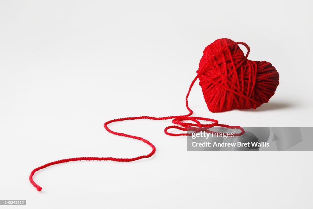 Red heart-shaped wool ball unraveling