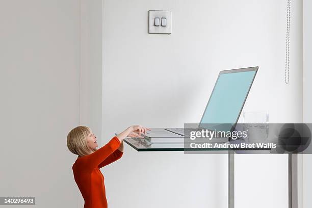 little businesswoman reaches for giant laptop - too much stock pictures, royalty-free photos & images