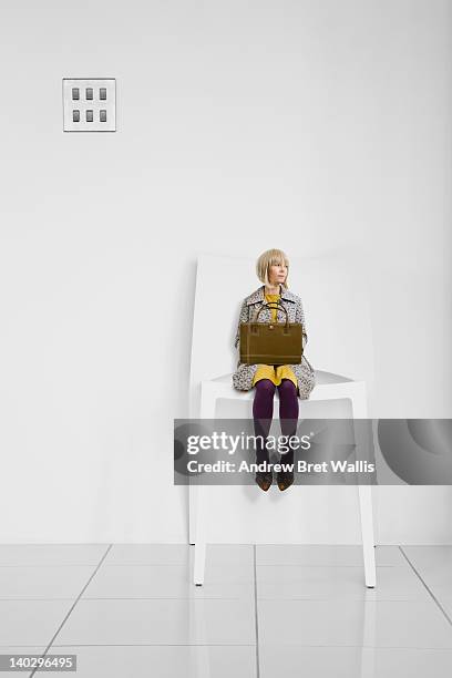 little businesswoman waits in a giant office chair - miniature stock-fotos und bilder