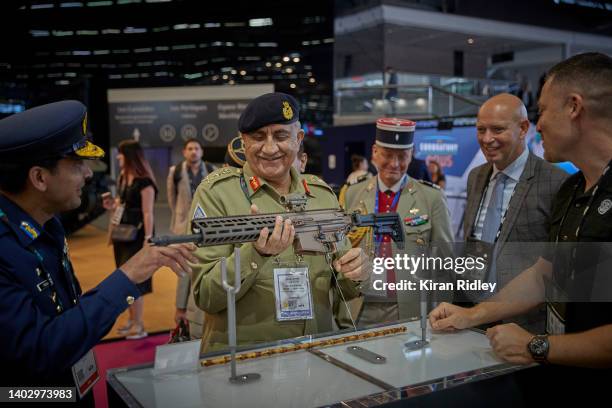 General Qamar Bajwa of the Pakistan Army examines a riffle on the SIG Sauer stand at the Eurosatory International Defence and Security Exhibition on...
