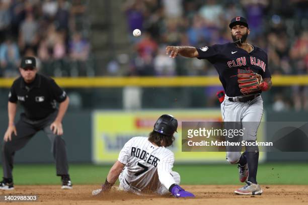 Amed Rosario of the Cleveland Guardians completes the first half of a double play against Brendan Rodgers of the Colorado Rockies on a C.J. Cron...