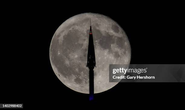 The full Strawberry Supermoon rises behind the antenna on top of One World Trade Center in New York City on June 14 as seen from Jersey City, New...