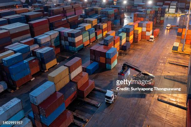 aerial view forklift handling container load to container truck at night for business logistics, import export, shipping or freight transportation. - cantiere navale foto e immagini stock