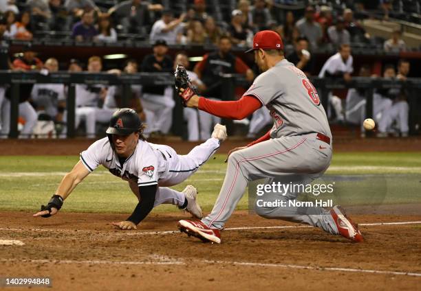 Jake McCarthy of the Arizona Diamondbacks scores on a wild pitch by Luis Cessa of the Cincinnati Reds during the 11th inning at Chase Field on June...