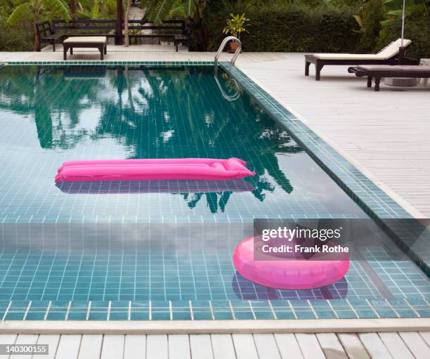 swimmingpool with nice water and a pink lilo - luftmatraze stock-fotos und bilder