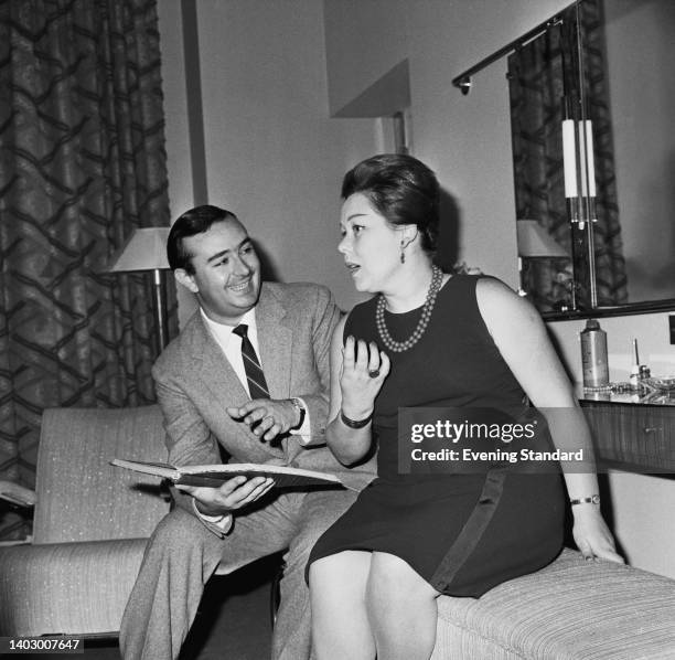 Italian violinist and manager Lorenzo Anselmi and his wife, Italian opera singer Renata Scotto wearing a sleeveless black dress with a double strand...