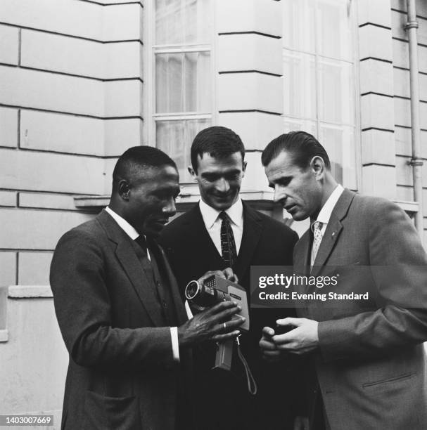 Brazilian footballer Djalma Santos holding a Canon Reflex Zoom 8 8mm movie camera, watched by Serbian footballer Milutin Soskic and Soviet goalkeeper...