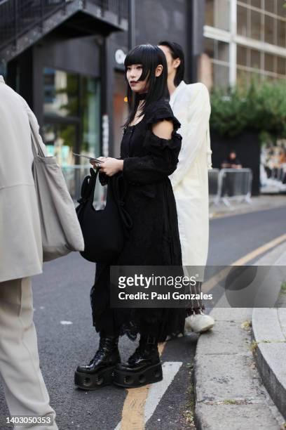 Guest is seen wearing a Black Dress with a Pair of Chunky Black Leather Boots. At The University of Westminster MA Menswear during London Fashion...
