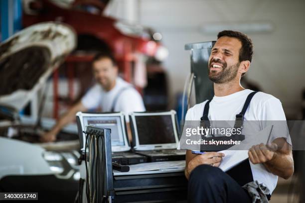 junge mechaniker mit spaß in auto-reparatur-shop. - how we listen to music stock-fotos und bilder