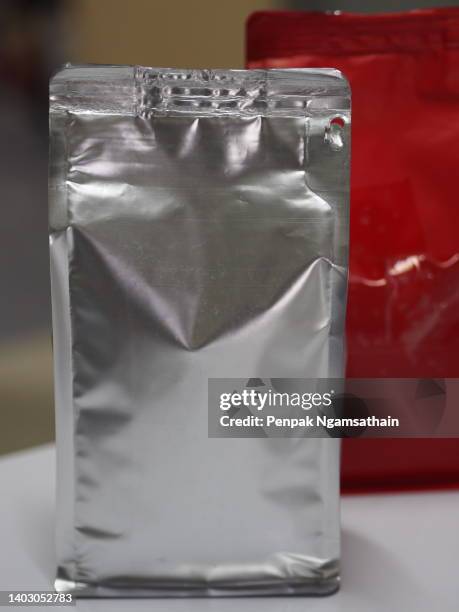 roasted coffee in foil bag on the table - coffee package stock-fotos und bilder