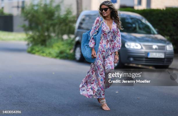 Gitta Banko seen wearing a Bottega Veneta sunglasses, a long maxi floral dress from Dea Kudibal with long sleeves, rhinestone sandals from Aminah...