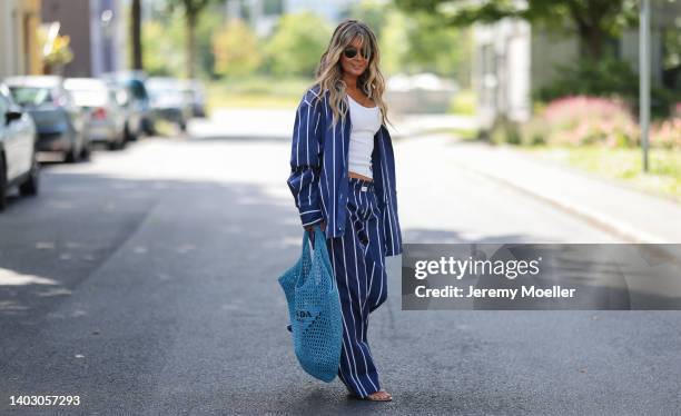 Gitta Banko seen wearing a Ray Ban sunglasses, a white tank top, a blue/white striped cotton pyjama set from Yaitte, rhinestone sandals from Aminah...