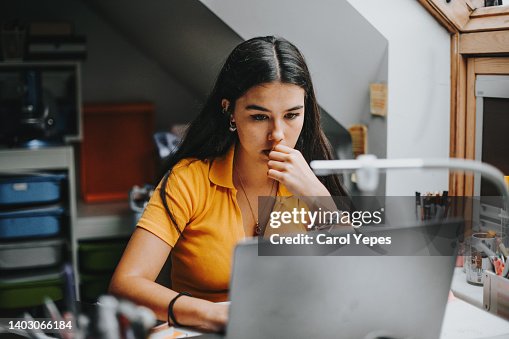 Hispanic college student doing some home works from home with laptop Hispanic college student doing some home works from home with laptop