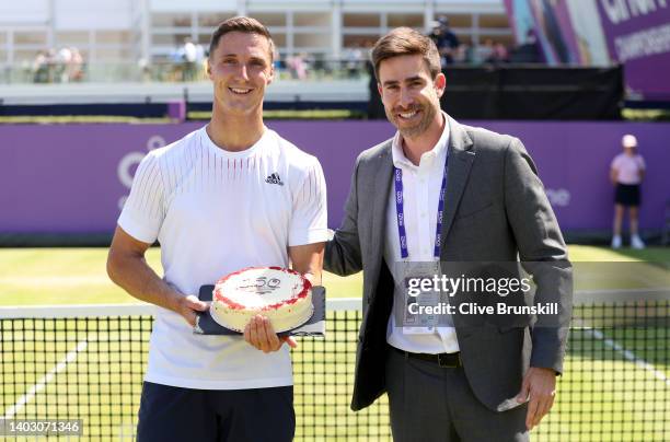 Joe Salisbury of Great Britain is presented with a cake by Luiz Carvalho of the LTA to commemorate winning his 150th doubles match, after winning...