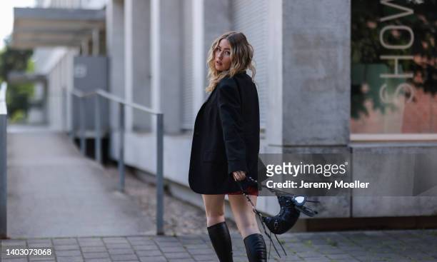 Sonny Loops seen wearing a pink logo short dress from Unfollowed, a black oversize blazer, a black leather Balenciaga Cagole shoulder bag and black...