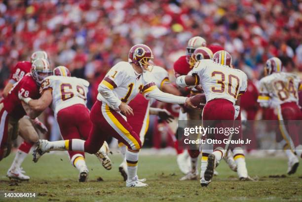 Mark Rypien, Quarterback for the Washington Redskins hands the ball off to Running Back Brian Mitchell during the National Football Conference...