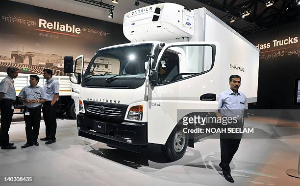 Indian executives from Daimler India Commercial Vehicles Private Limited stand near a truck at a press conference for the national launch of Bharat...