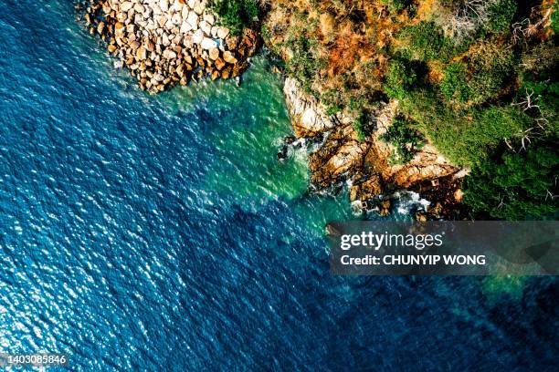 luftaufnahme der meereswellen, des strandes und der felsigen küste und des wunderschönen waldes - hongkong geopark stock-fotos und bilder