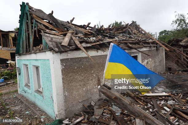 Ukrainian flag flies next to a home that was heavily damaged by a Russian rocket attack on June 15, 2022 in Dobropillia, Ukraine. Yesterday the...