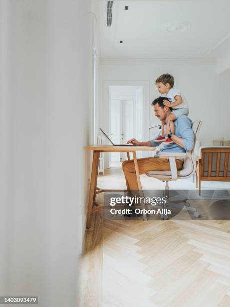 father working at home while taking care of his - modern manhood stock pictures, royalty-free photos & images