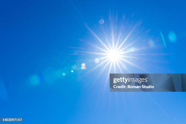 sunburst with lens flare. clear sky, sun, blue sky - sunlight foto e immagini stock