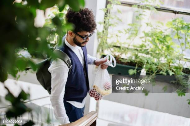 young man with eco-friendly reusable cotton bag, zero waste concept - duurzaam consumeren stockfoto's en -beelden