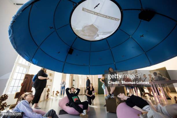 Visitors watch the video installation 'Walemba - The story of the wanzo wa Mikub' of the 'Centre d'Art Waza' at the Fridericianum during the first...