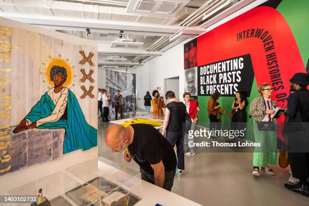 Visitors and artist speak in 'The Black Archives' at the Fridericianum during the first preview day at the documenta 15 modern art fair on June 15,...