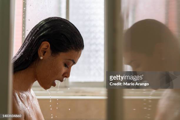 la mujer latina está en el baño de su casa recibiendo un delicioso baño - taking a bath fotografías e imágenes de stock