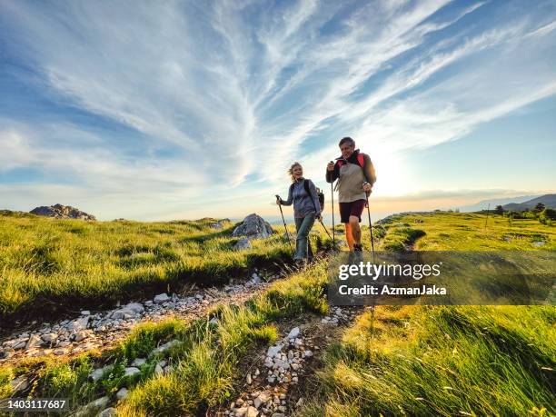 two seniors hiking and walking off the beaten path - nordic walking stock pictures, royalty-free photos & images