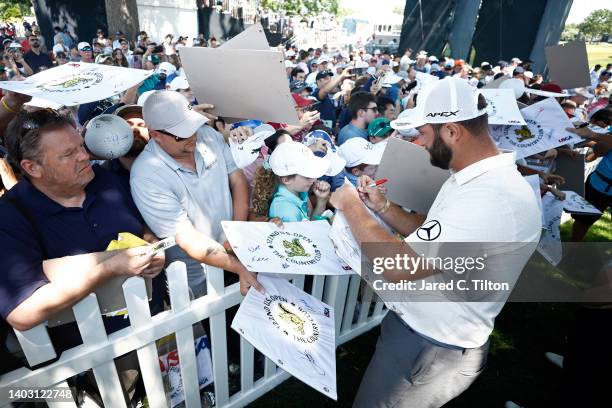 Jon Rahm of Spain signs his autograph for a fan during a practice round prior to the 122nd U.S. Open Championship at The Country Club on June 15,...