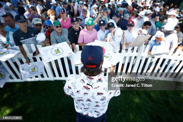 Rickie Fowler of the United States signs his autograph for a fan during a practice round prior to the 122nd U.S. Open Championship at The Country...