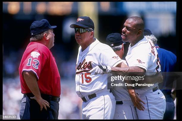 Outfielder Bobby Bonilla of the Baltimore Orioles restrains his manager Davey Johnson during a confrontation with the umpire in a game against the...