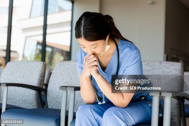 surgeon sits alone - nurse praying stock pictures, royalty-free photos & images