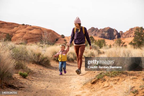 a mother and her daughter hiking a sandy foot path. - st george utah stock pictures, royalty-free photos & images