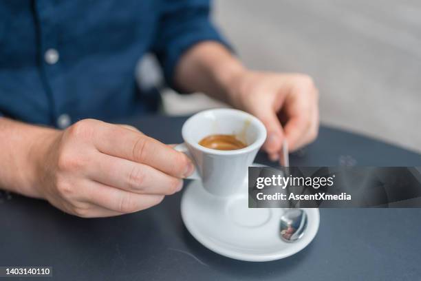 young man enjoys an espresso at an outdoor cafe - espresso stock pictures, royalty-free photos & images