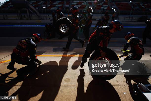 Team mechanics run out as Sebastian Vettel of Germany and Red Bull Racing drives in for a pitstop during day two of Formula One winter testing at the...