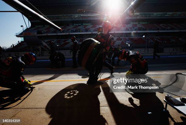 Team mechanics run out as Sebastian Vettel of Germany and Red Bull Racing drives in for a pitstop during day two of Formula One winter testing at the...