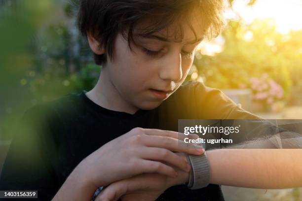 ragazzo che chiama sua madre sul suo orologio intelligente. - boy pre adolescent phone hand foto e immagini stock