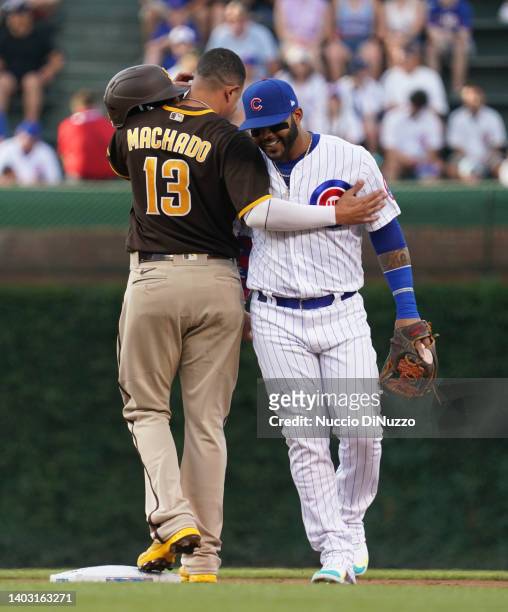 Manny Machado of the San Diego Padres puts his arm around Jonathan Villar of the Chicago Cubs at after reaching second base following his 1500th MLB...