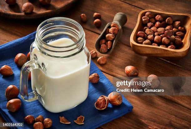 non-dairy hazelnut milk on rustic wooden table - hazelnut meal stockfoto's en -beelden