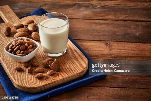 glass with almond milk on rustic wooden table with copy space - almond milk stock pictures, royalty-free photos & images