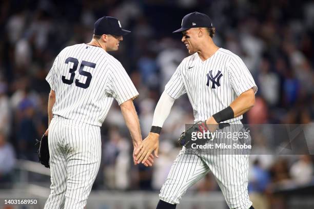 Aaron Judge and Clay Holmes of the New York Yankees celebrates after defeating the Tampa Bay Rays 4-3 at Yankee Stadium on June 15, 2022 in the Bronx...