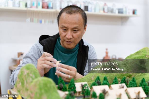 an asian man working on a microscopic model - model kit 個照片及圖片檔