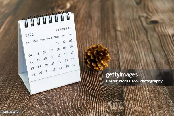 december 2022 desk calendar with potted plant on top of wood desk - wood desk ストックフォトと画像