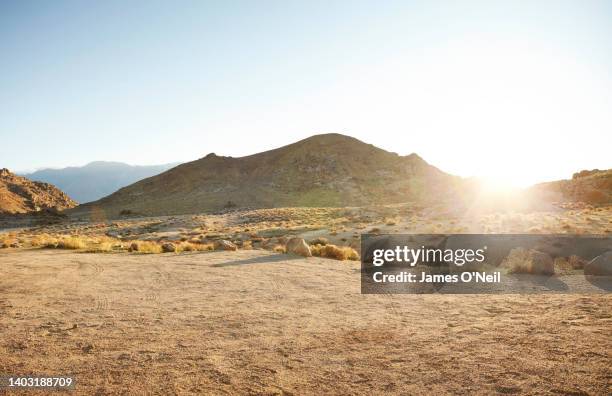 dirt parking area in desert landscape and distant mountains - strada di campagna foto e immagini stock